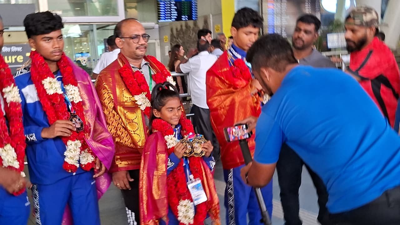 Rakshathra garlanded on return from the Uzbekistan Kickboxing World Cup, with her father and coach