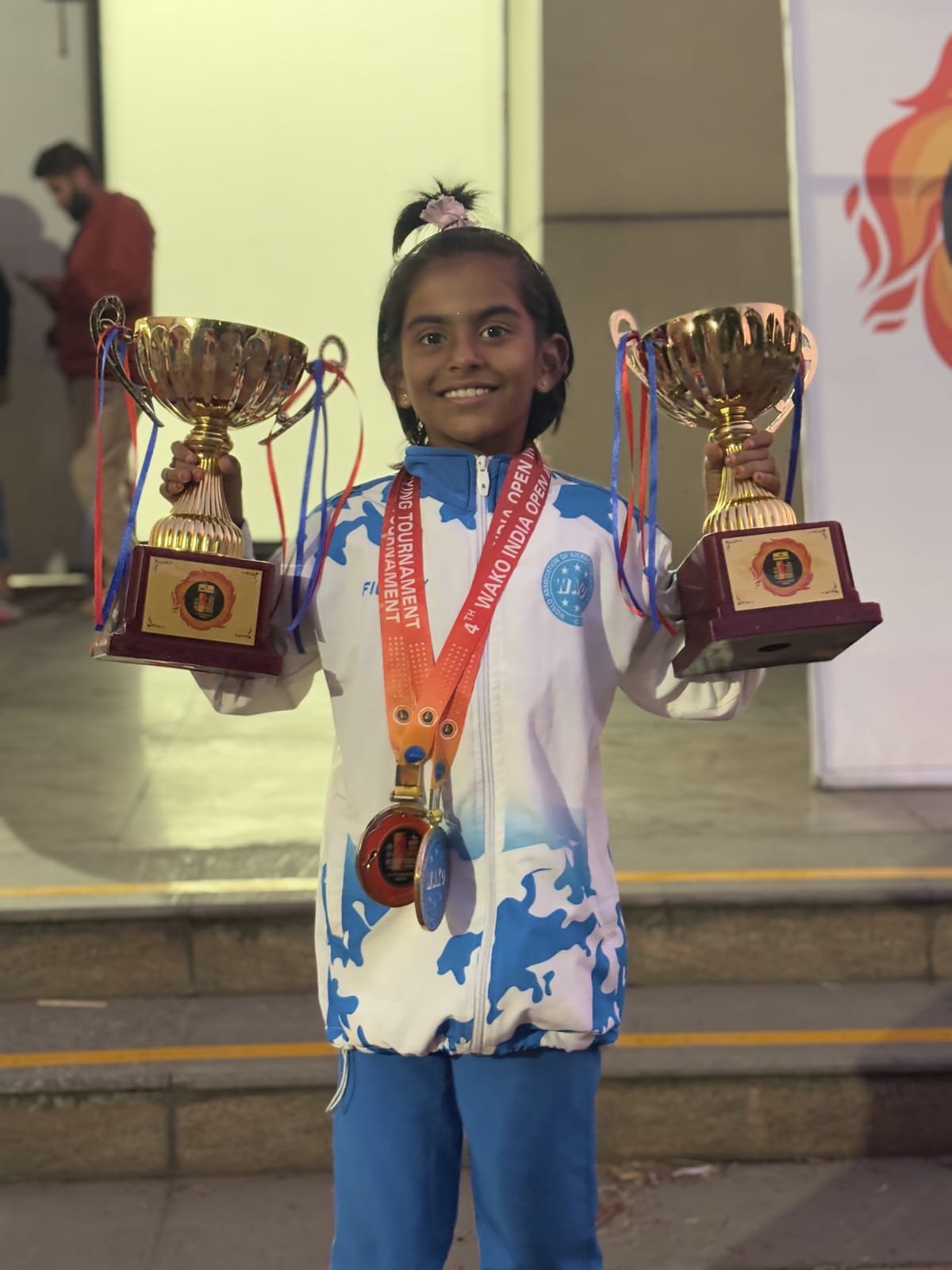 Rakshathra holding two trophies and medals at the 4th WAKO India Open International Kickboxing Tournament