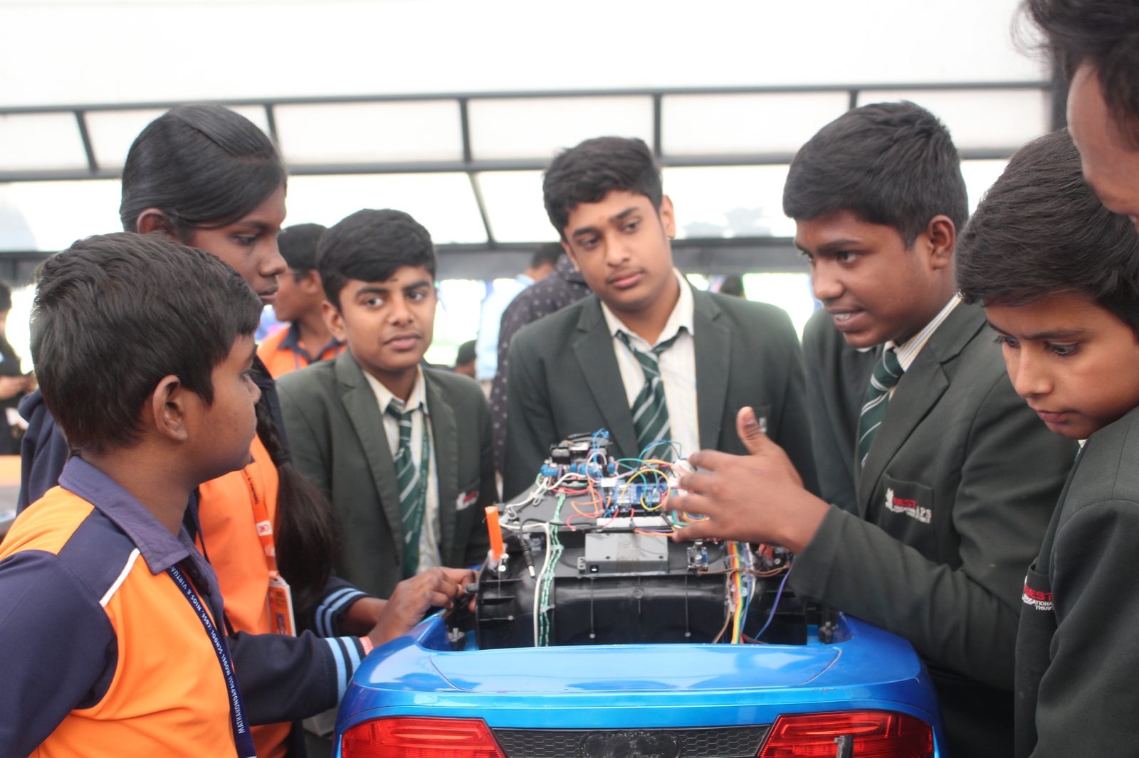 Visiting students examining the electronics inside the Autopilot Car