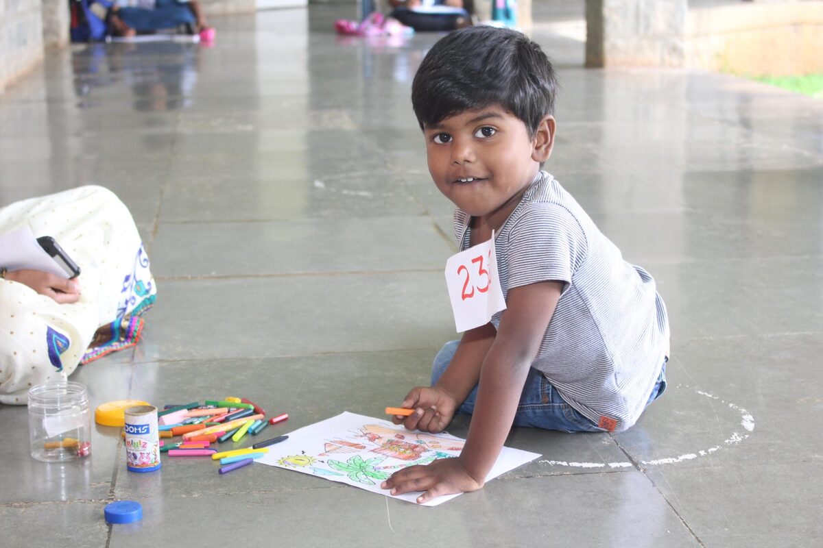 A young participant proudly showing off his artwork during an art competition