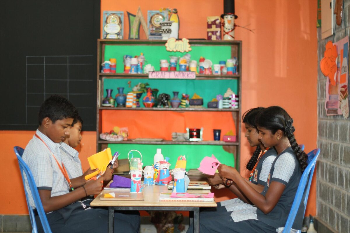 Two students crafting decorative items together at a table