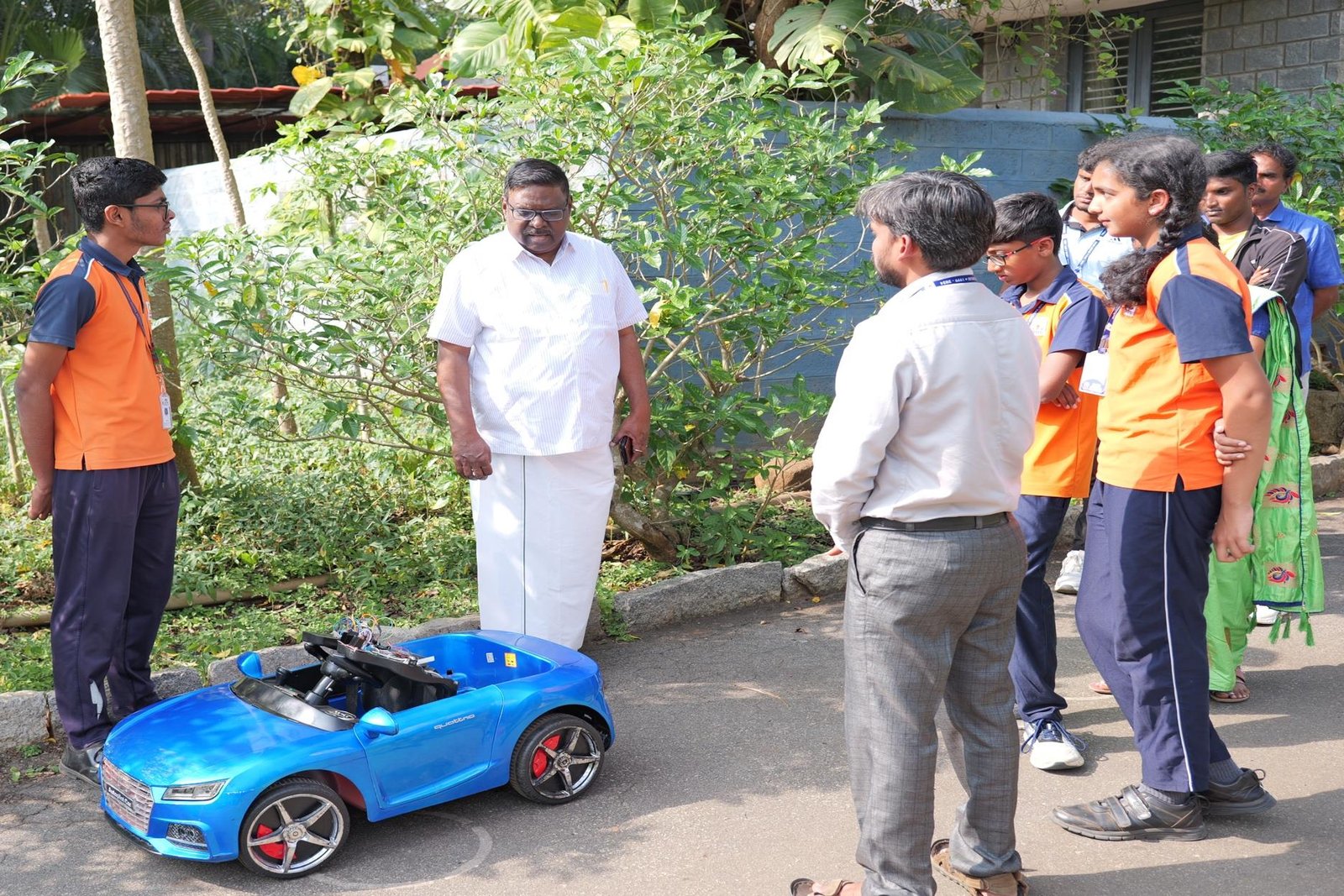 Students demonstrating their autopilot car prototype to a visiting dignitary