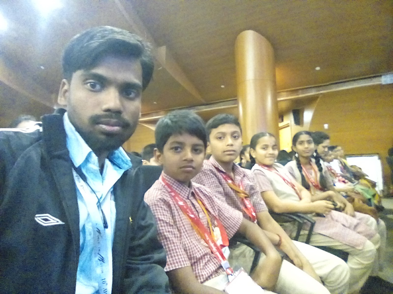 MMS students and accompanying teacher seated together at the AWIM National Olympics venue in Pune, 2018