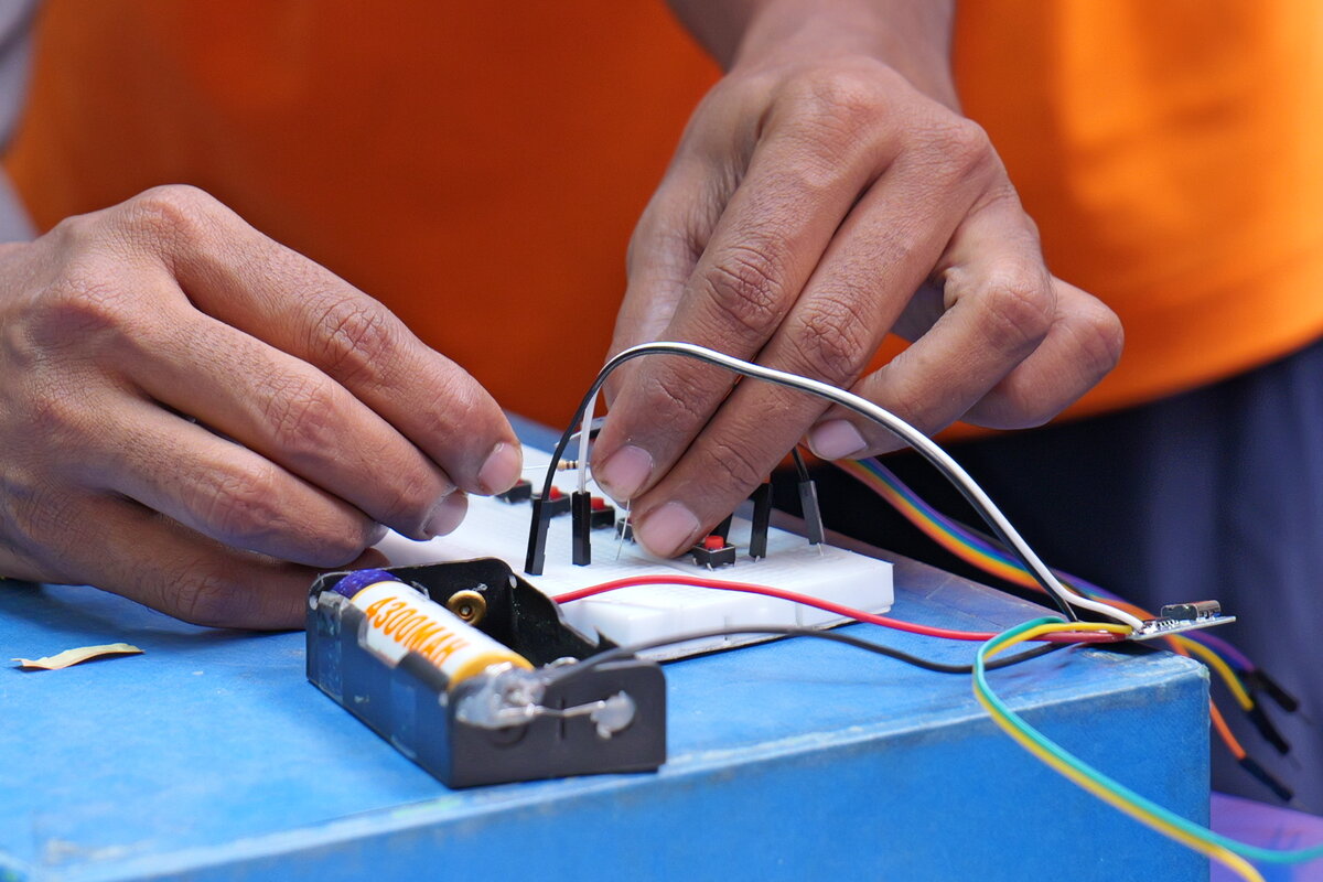 Close-up of hands connecting a rechargeable battery pack to the circuit