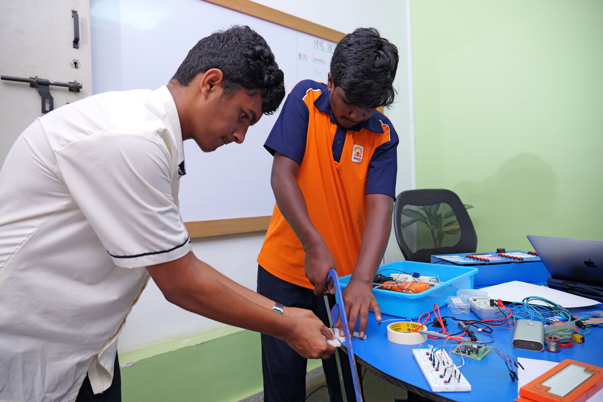 Two students preparing and trimming wires for the panel