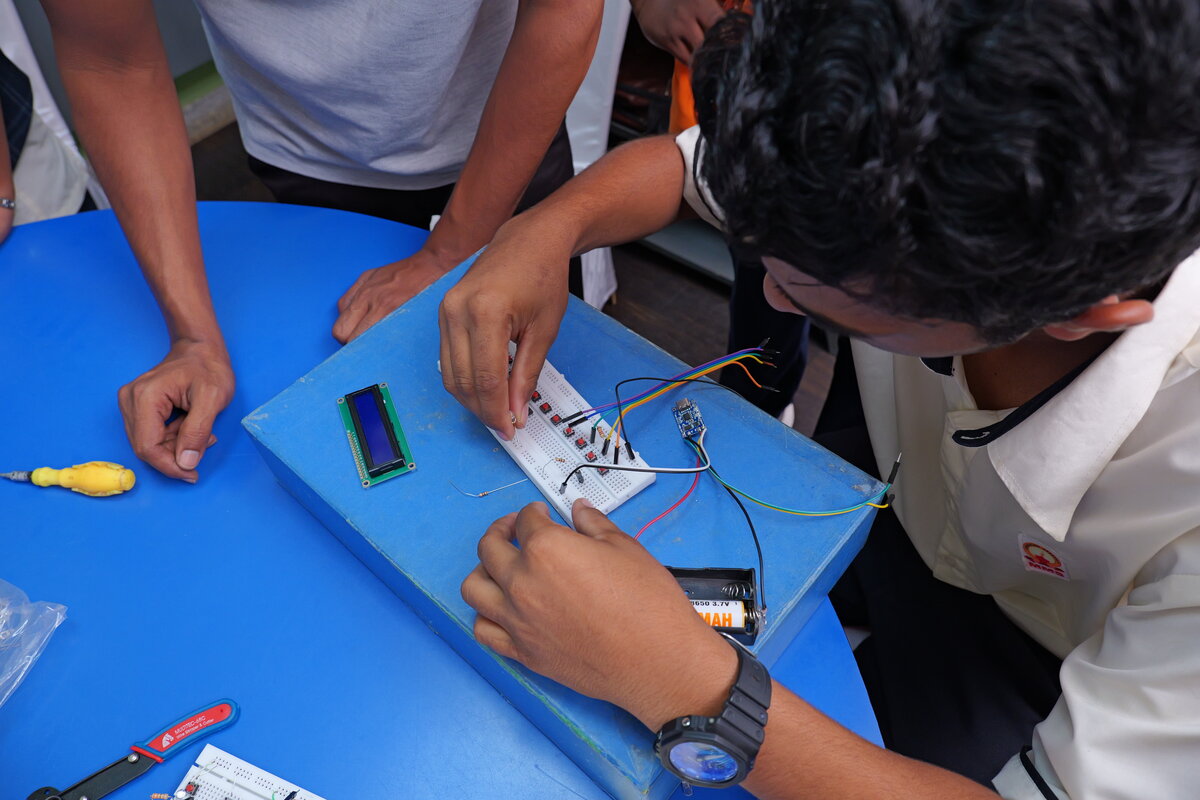 Students wiring the LCD display and battery holder into the enclosure