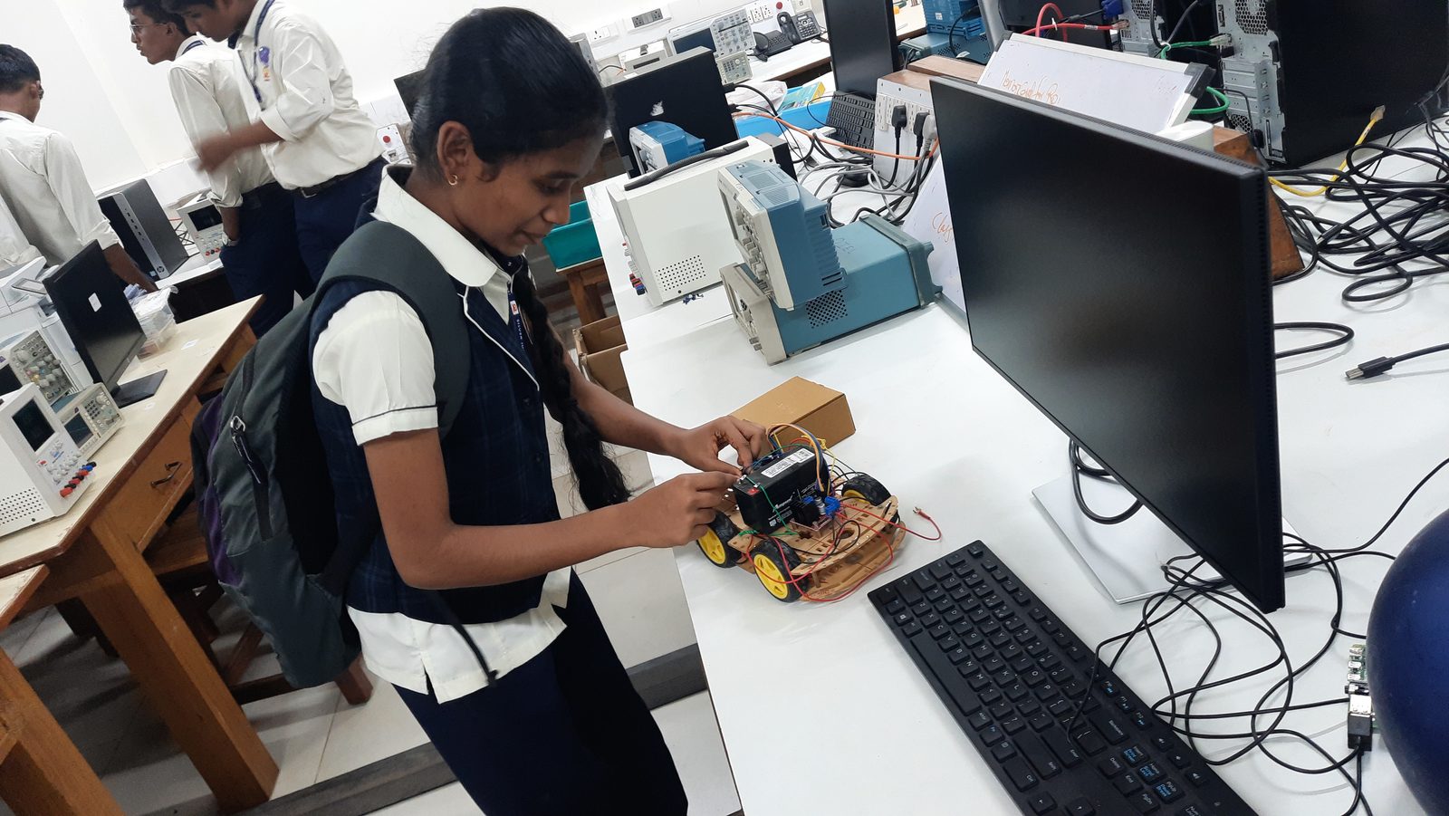 MMS student working hands-on with a robotics kit in a campus lab