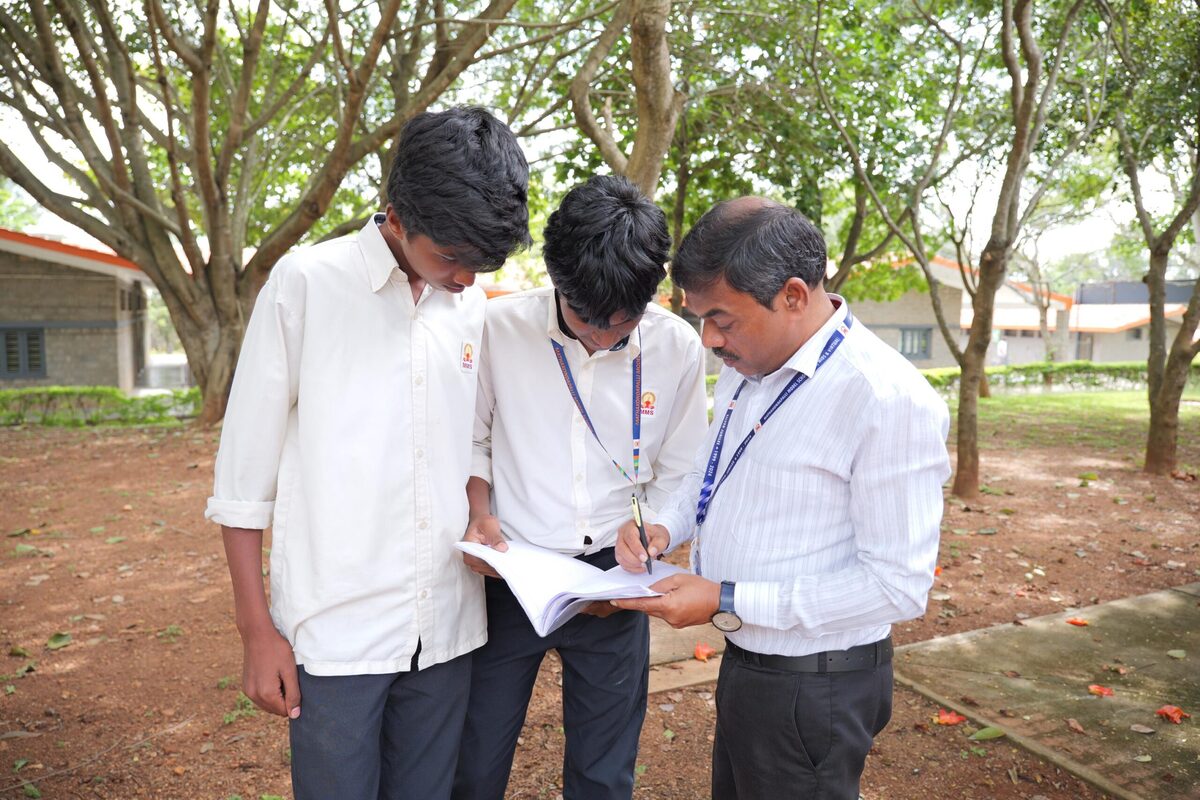 Staff and students discussing an ecology field-study plan outdoors