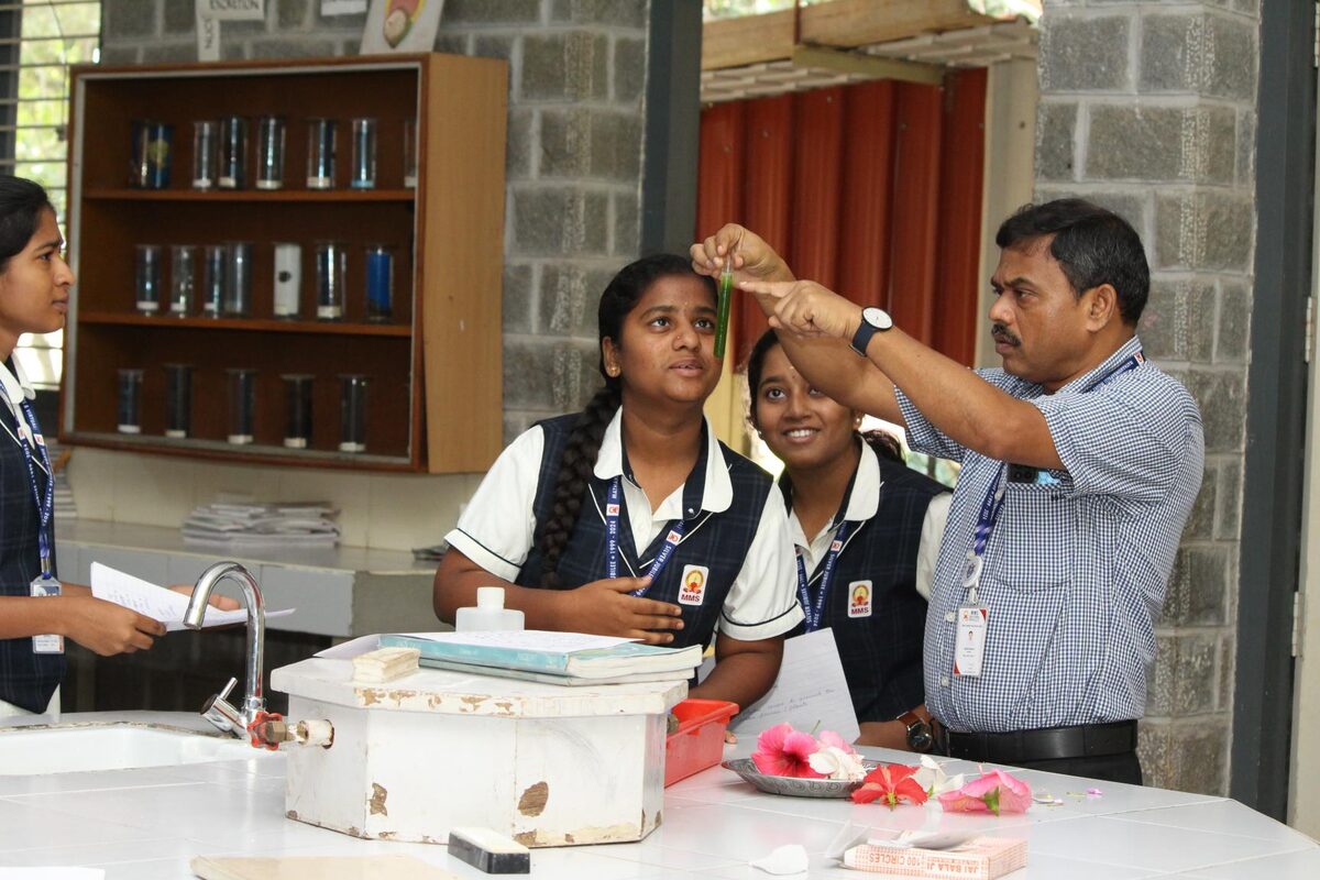 Students and staff gathered around a specimen during a Biology Lab session