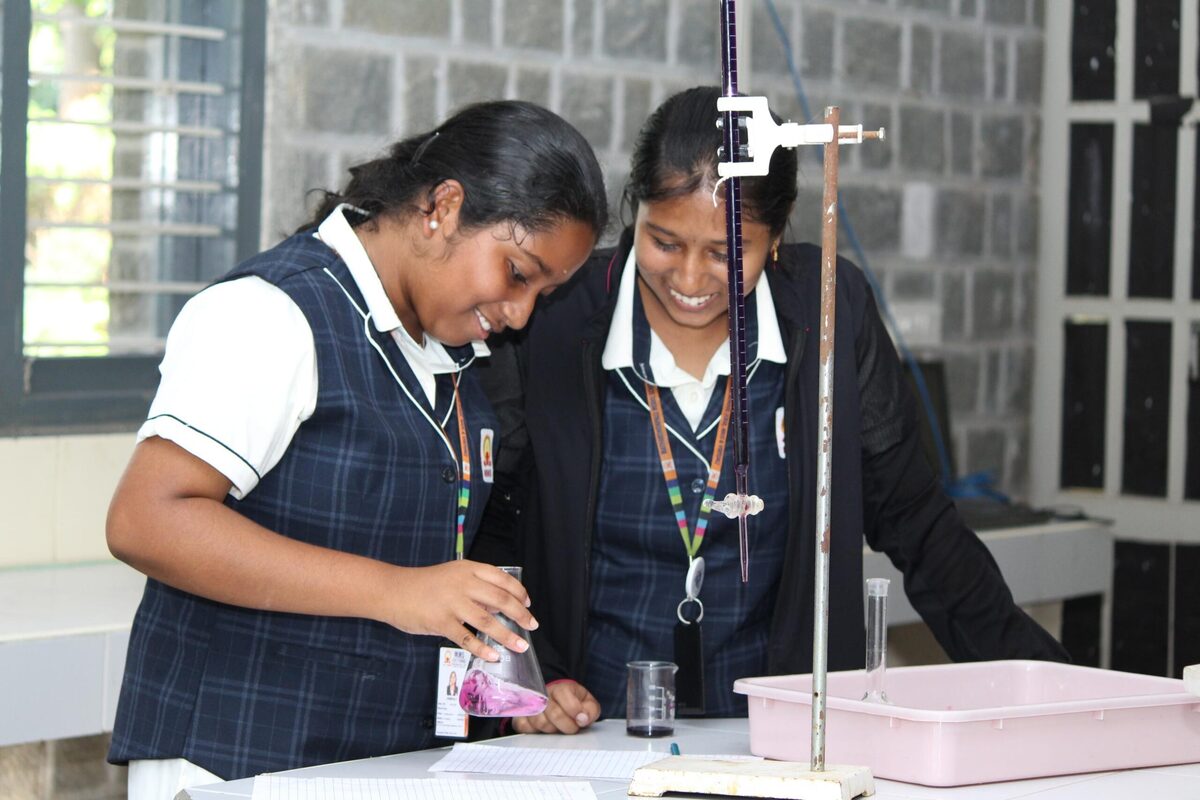 Students setting up a titration using a burette stand