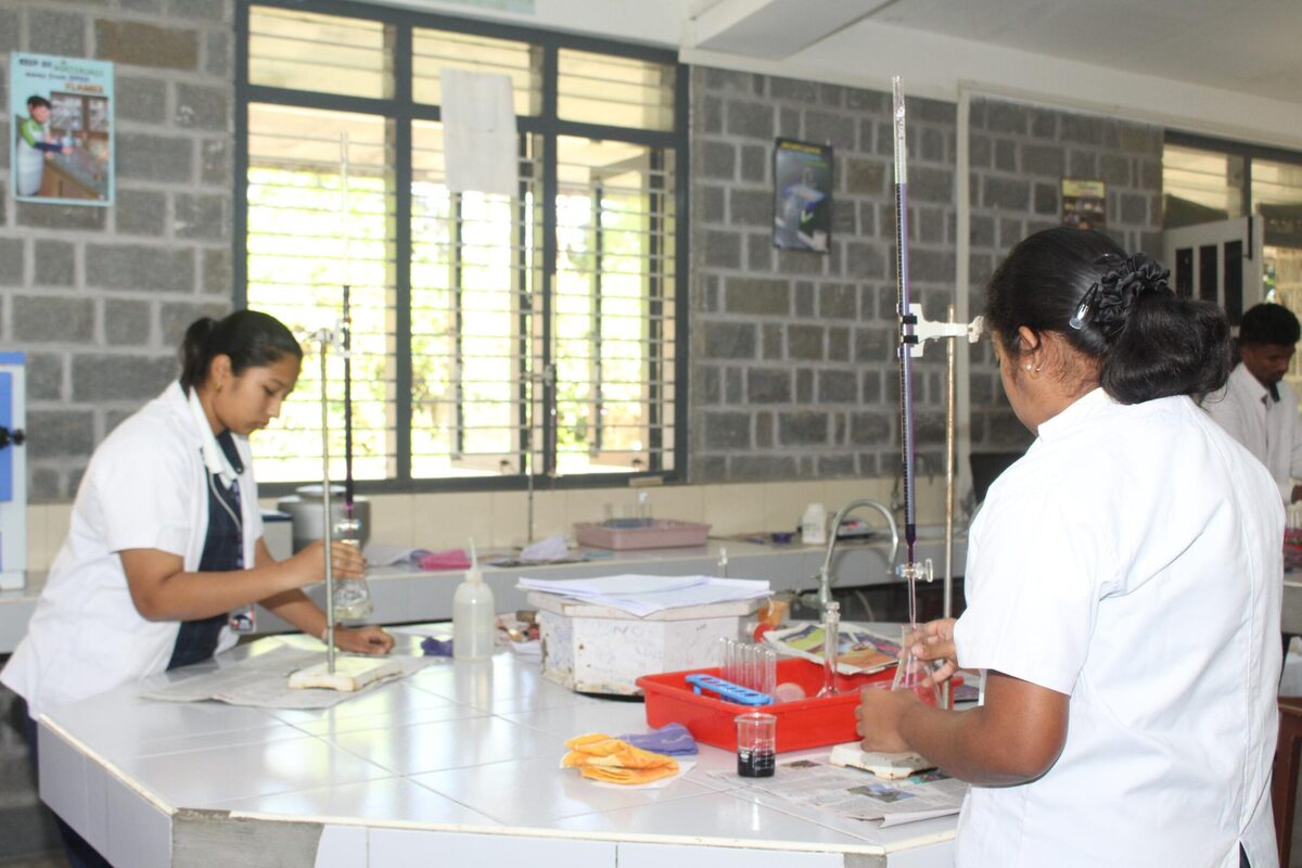 Students working through a chemistry practical at their lab station