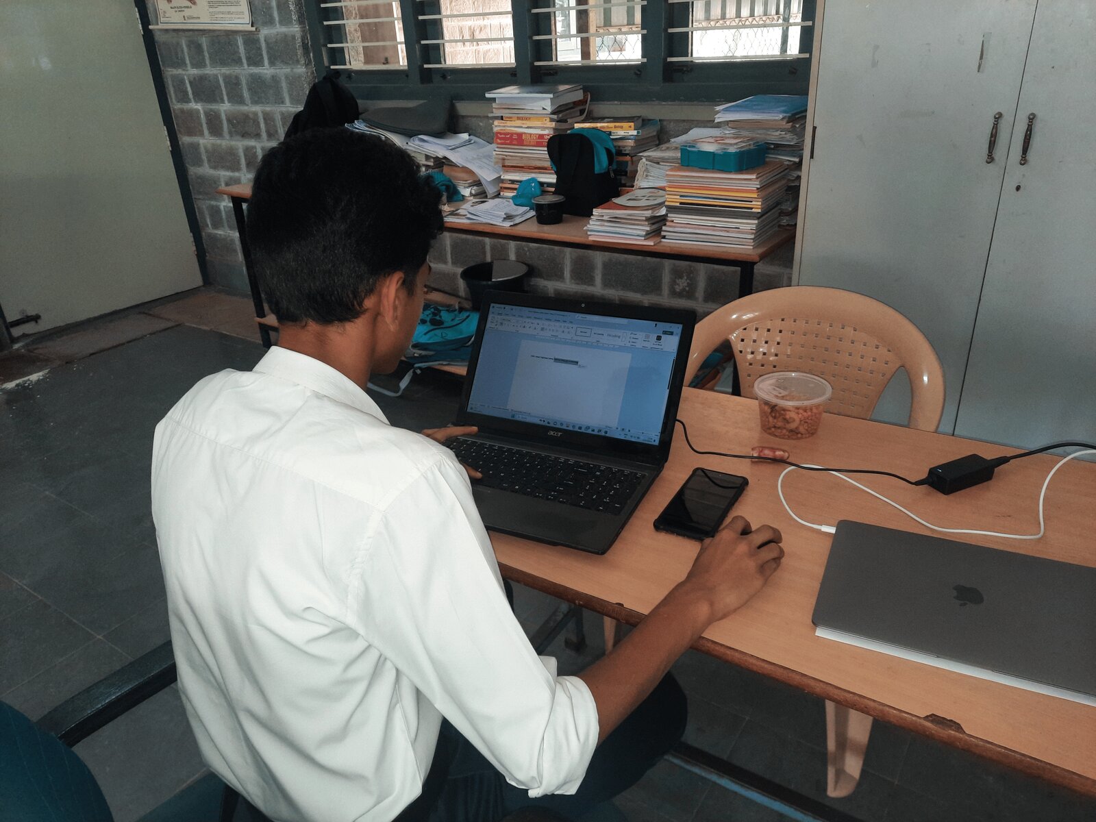 A student writing up the project documentation on a laptop