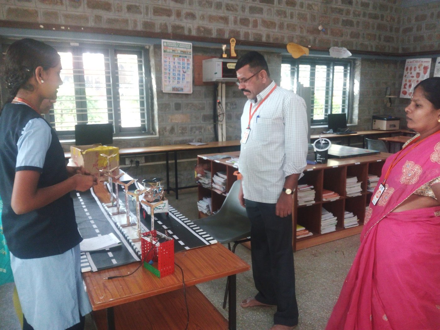 Student demonstrating the LiFi Road Safety project model to teachers