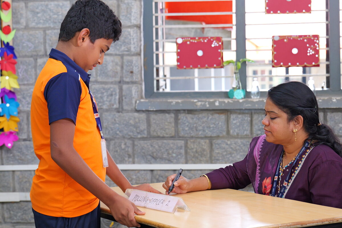 A polling officer marking a voter's finger with indelible ink