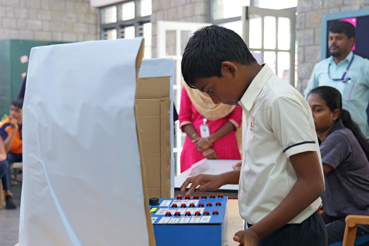 A teacher verifying a student's details before they cast their ballot