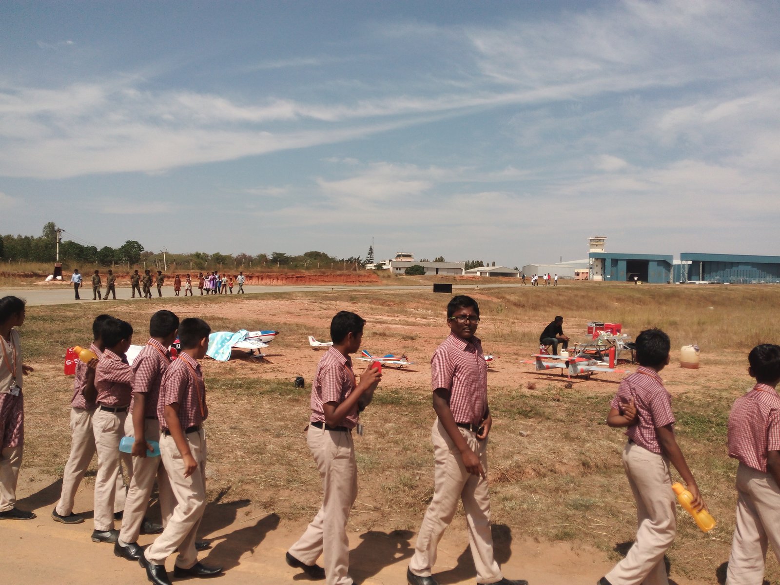 Model aircraft on display on the tarmac at TALL, Hosur Airdrome, with MMS students queued up nearby