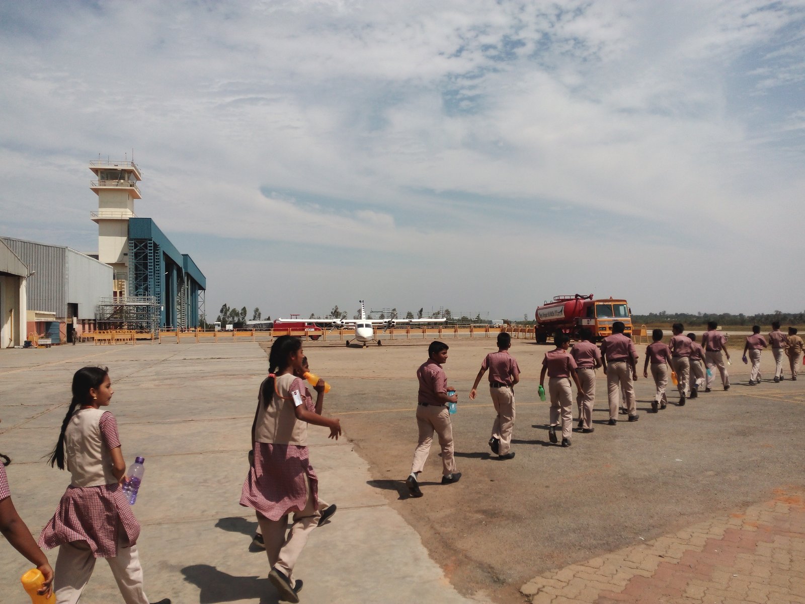 MMS students walking across the tarmac towards the hangar at TALL, Hosur Airdrome