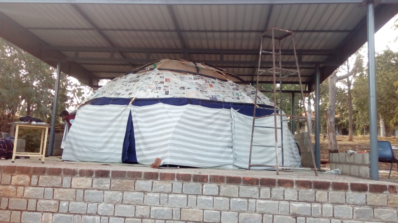 The exterior of the Version 2 planetarium dome, weatherproofed with a newspaper layer and striped fabric covering