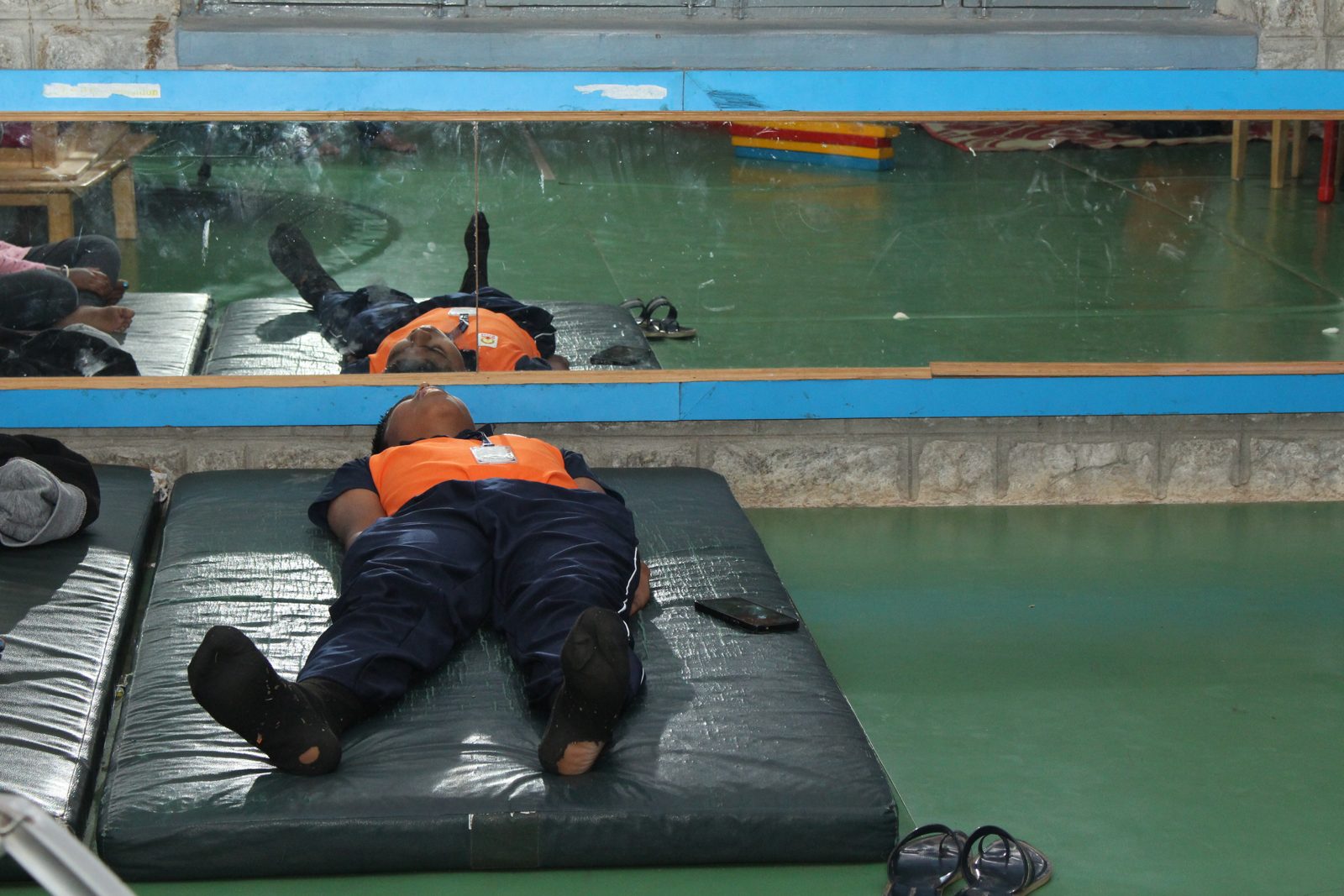 A student resting on a mat in the activity room
